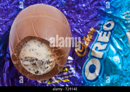 Oeuf de Pâques Oreo déballés et commencé à afficher le contenu du panier situé sur aluminium - chocolat au lait oeuf à la crème de lait et de remplissage pièces biscuit Banque D'Images