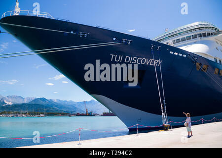 Porto di Carrara, Italie. Bateau de croisière découverte à quai. Femme points à grand navire dans le dock. Banque D'Images