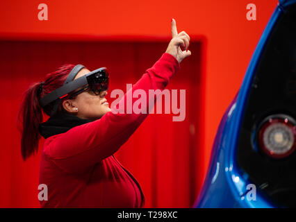 Hanovre, Allemagne. Mar 31, 2019. 31 mars 2019, Hanovre, Basse-Saxe : Sur un stand du fabricant allemand de la technologie d'entraînement de SEW EURODRIVE, une femme se tient sur une ligne de production automatisée avec lunettes holographiques sur lequel elle reçoit les instructions de travail et permet de vérifier avec des gestes. Du 1er au 5 avril, tout à la Hannover Messe se déroulera autour de la mise en réseau, les machines d'apprentissage et de l'Internet des objets. Photo : Christophe Gateau/dpa dpa : Crédit photo alliance/Alamy Live News Banque D'Images