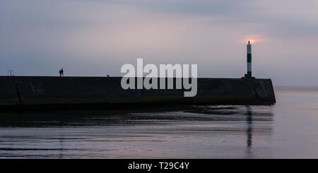 Aberystwyth, UK. 31 mars 2019 UK Weather : Après une journée calme à Aberystwyth le soleil commence à se coucher derrière le nuage et le phare sur la côte ouest. © Ian Jones/Alamy Live News Banque D'Images