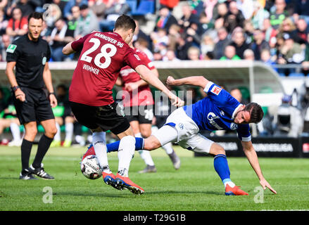 Hanovre, Allemagne. Mar 31, 2019. Schalke 04 Mark Chu (R) rivalise avec Hanovre 96's Kevin Wimmer lors d'un match de Bundesliga allemande entre Hanovre 96 et le FC Schalke 04, à Hanovre, en Allemagne, le 31 mars 2019. Schalke 04 a gagné 1-0. Crédit : Kevin Voigt/Xinhua/Alamy Live News Banque D'Images