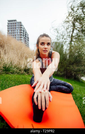 Vue rapprochée du sport femme streching assis jambes outdoor Banque D'Images