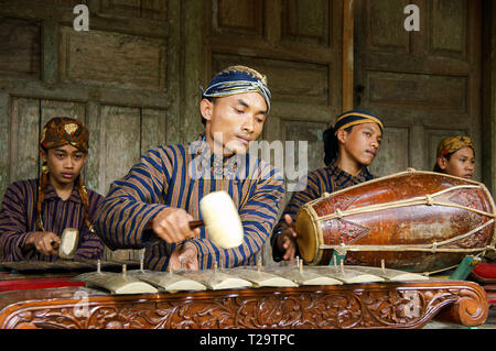 Un groupe de jeunes jouant avec le gamelan javanais en utilisant blangkon lurik, et vêtements traditionnels Banque D'Images