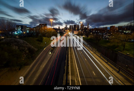 Leeds City skyline with light trails qui mène à elle. Banque D'Images