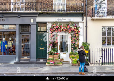 Une femme se tenant à l'extérieur du magasin d'art floral Moyses Stevens à Belgravia, Londres, Royaume-Uni Banque D'Images