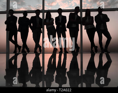 Silhouette d'une équipe entreprises debout à côté de la fenêtre du bureau Banque D'Images