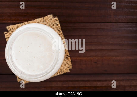 Des bubbly levain fermenté, un mélange d'eau et de farine à utiliser comme ferment pour la cuisson du pain, dans un bocal en verre, photographié les frais généraux Banque D'Images