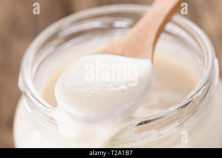 Des bubbly levain fermenté, un mélange d'eau et de farine à utiliser comme ferment pour la cuisson du pain, sur cuillère en bois Banque D'Images