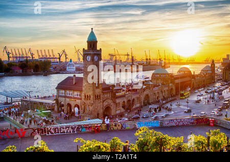 Coucher de soleil sur le St Pauli Landungsbrücken ou jetées dans le port de Hambourg, Allemagne. Banque D'Images