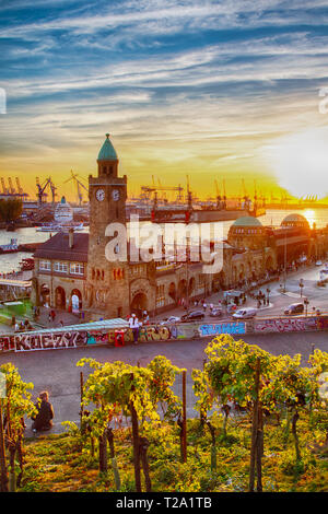 Coucher de soleil sur le St Pauli Landungsbrücken ou jetées dans le port de Hambourg, Allemagne. Banque D'Images