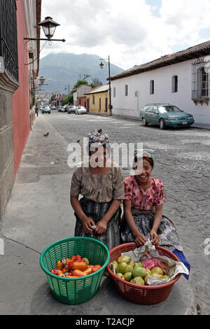 Antigua, Guatemala 03-01-2008 Deux jeunes filles en costume traditionnel local vendre fruits et légumes sur un trottoir à Antigua. Banque D'Images