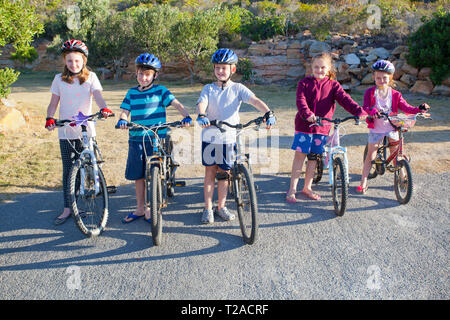 Cinq jeunes enfants sur des vélos à l'infante. Banque D'Images