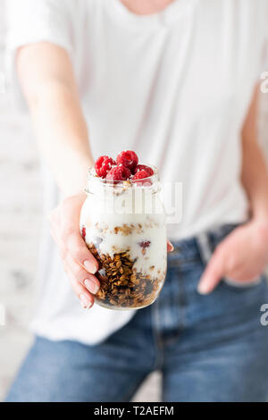 Pot de yaourt muesli parfait à main de la jeune fille. Régime alimentaire équilibré repas. La culture alimentaire à la mode Banque D'Images