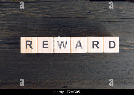 Mot récompenser écrit sur un cube de bois. Le risque et la récompense concept Banque D'Images