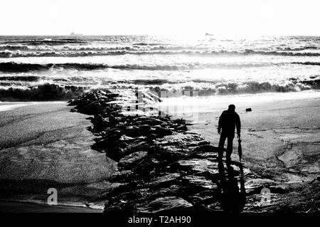 Un homme sur la plage regarde l'état de la mer Banque D'Images