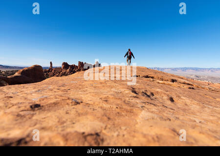 Homme randonnée sur roche dans Arches National Park, Utah, USA Banque D'Images