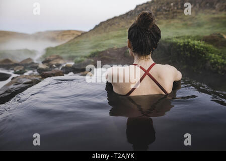 Rear view of woman in piscine chaude Islande Banque D'Images
