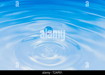 Couleur bleu goutte d'eau splash et ondulations. Macro shot Banque D'Images