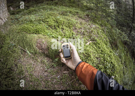 A l'aide du GPS Trekker parmi la forêt dans un jour nuageux Banque D'Images