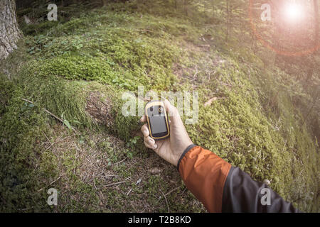 A l'aide du GPS Trekker parmi la forêt dans un jour nuageux Banque D'Images