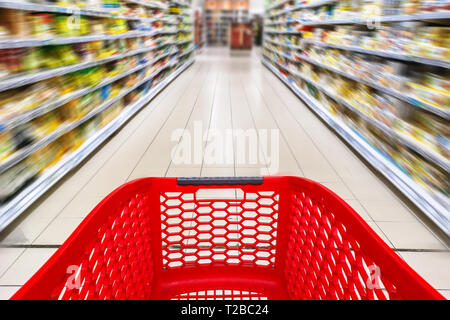 Panier vide rouge dans une allée de supermarché, le motion blur Banque D'Images
