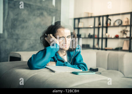 Dark-haired confus jeune musicien d'être coincé au cours de création des processus Banque D'Images