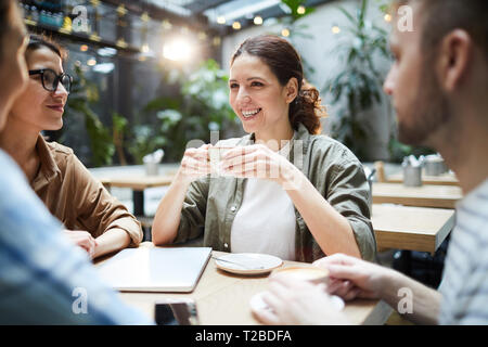 Happy friends drinking coffee in cafe Banque D'Images
