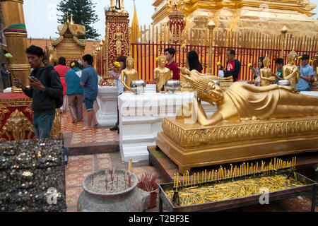 Fidèles au Wat Phra That Doi Suthep encerclant le Chedi avec Bouddha statue en premier plan de réfection Banque D'Images