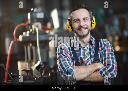 Smiling Worker Wearing casque antibruit Banque D'Images