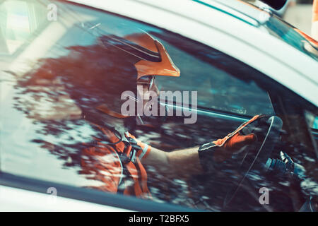 Pilote de rallye, l'homme au casque tendu et sérieusement à l'avant, vue de côté à la fenêtre à l'racer participant à la manifestation Banque D'Images