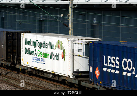 Moins de CO2 les conteneurs d'expédition ferroviaire om un freightliner train sur la West Coast Main Line passant DIRFT, Northamptonshire, Angleterre Banque D'Images