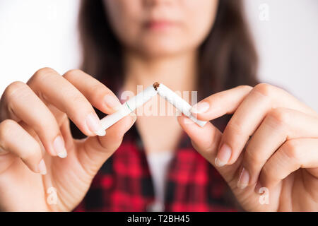 Journée mondiale sans tabac, le 31 mai. Arrêter de fumer. Close up femme part briser, écraser ou détruire les cigarettes. Banque D'Images