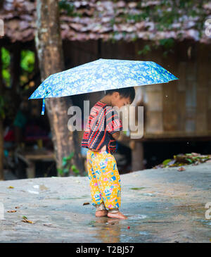Baan Tong Luang Chiang Mai THAÏLANDE 16 Avril 2018 jeune garçon joue dans la flaque d'eau de pluie Vie Tribal Village Karen Banque D'Images