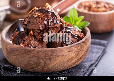 Libre de glace au chocolat aux noix de pécan et sauce dans un bol en bois Banque D'Images