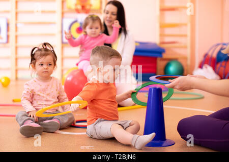 Groupe bébés pépinière faire du sport en salle de sport Banque D'Images