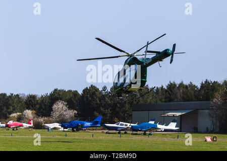 D'exploitation d'hélicoptères d'Essex & Herts Air Ambulance décoller de l'Aérodrome de Earls Colne dans l'Essex, le jour de printemps, une amende Banque D'Images