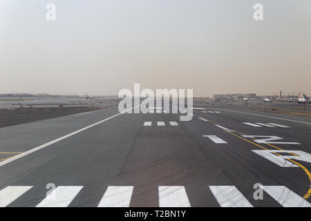 La piste de l'aéroport de Dubaï et les avions en stationnement unis Banque D'Images