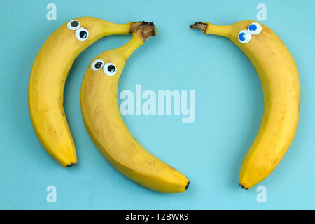Trois bananes avec yeux couinent Vue de dessus sur un fond bleu Banque D'Images