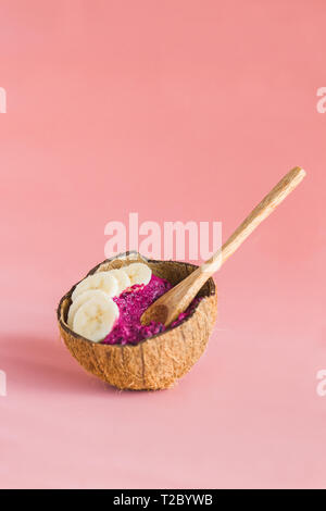 Petit-déjeuner végétalien sain, dans la noix de coco smoothie rose plaque , Bol fabriqué à partir de coquilles de noix de coco Banque D'Images