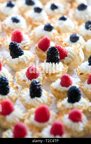 Détails de friandises de mariage avec crème blanche et de petits fruits noirs et de framboises Banque D'Images