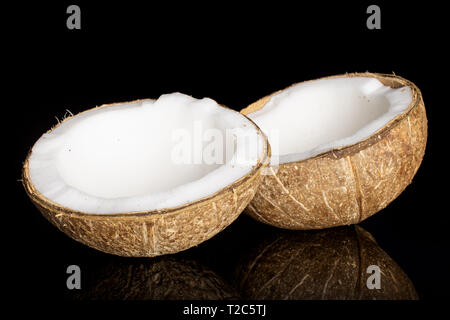 Groupe de deux moitiés de noix de coco bio frais isolé sur verre noir Banque D'Images