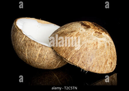 Groupe de deux moitiés de noix de coco bio frais tranchés un isolé sur verre noir Banque D'Images