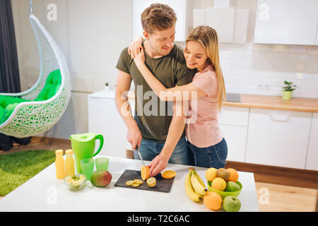 Jeune couple aimant la cuisson des fruits biologiques pour les jus à la table. Alimentation saine. Famille heureuse. La saine alimentation Banque D'Images