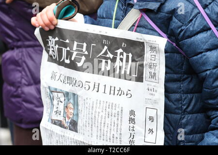 Un garçon est titulaire d'une copie de ces rapports édition d'un journal le nom de la nouvelle ère impériale, 'Reiwa', à Tokyo, au Japon, le 1 avril 2019. Le gouvernement japonais a officiellement annoncé la prochaine ère sera connu sous le nom de "ère" Reiwa le lundi, un mois avant Prince héritier Naruhito monte sur le trône après l'abdication de l'Empereur Akihito. Credit : Naoki Nishimura/AFLO/Alamy Live News Banque D'Images