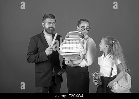 Processus de formation avec de nombreux livres dans les mains des filles avec l'enseignant. formation à l'examen à l'école. Banque D'Images