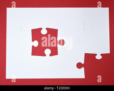 Grand blanc puzzles en blanc sur fond rouge, vue du dessus Banque D'Images