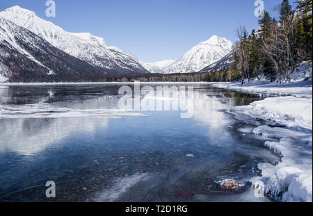Montana Lake en hiver : montagnes couvertes de neige représentent de la surface glacée du lac McDonald, dans le parc national des Glaciers. Banque D'Images