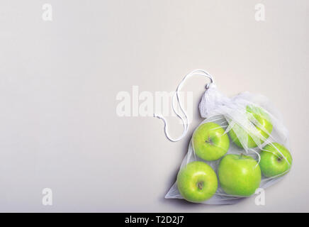 Les pommes en sac-filet, concept zéro déchet, Eco Friendly Panier sur fond beige Banque D'Images