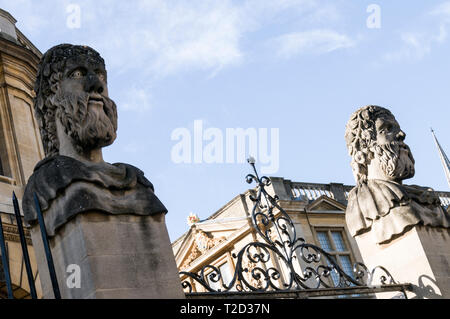 Une rangée de têtes sculptées en pierre montée sur le parapet et embarquement à l'Sheldonian Theatre dans Broad Street, Oxford, Angleterre. On ne sait pas qui le Banque D'Images