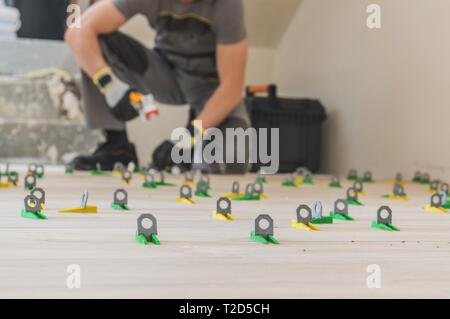 Système de mise à niveau de sol installé par des carreaux de céramique d'installation. Thème industriel. Accueil l'aménagement intérieur. Banque D'Images